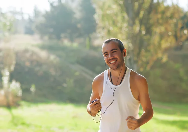 Jongeman joggen in het park. Gezondheid en fitness. — Stockfoto