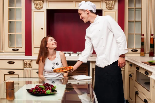 Chef brings the pizza to the client — Stock Photo, Image