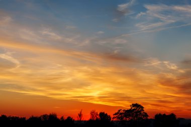 Parlak turuncu ve sarı günbatımı gökyüzü