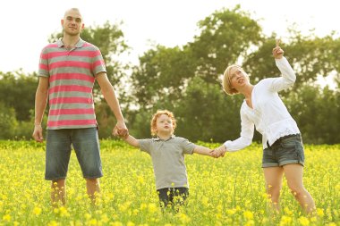 mutlu bir aile ayçiçeği tarlası içinde eğleniyor. Baba oğluna sarılarak.