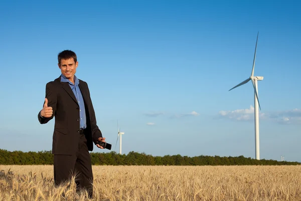 Happy businessman in a field