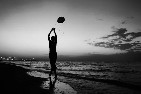 Silhueta de uma menina ao amanhecer com as contas. O conceito de livre — Fotografia de Stock