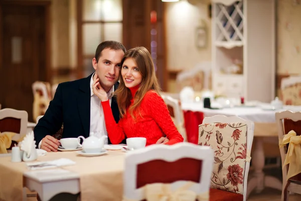 Romântico jovem casal sentado em um restaurante — Fotografia de Stock