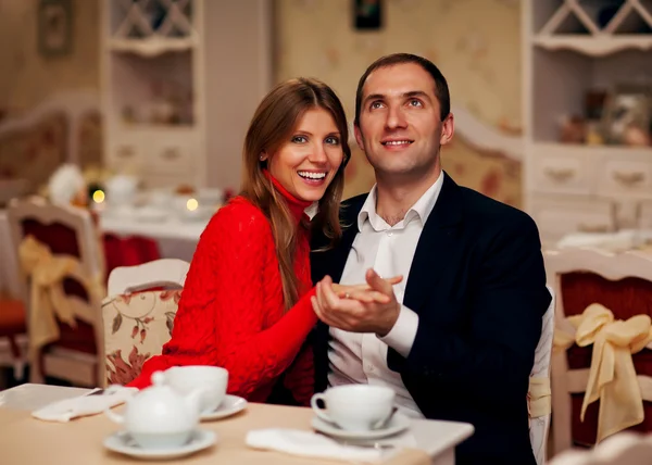 Jong koppel genieten van koffie en gebak in café — Stockfoto