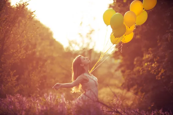 Baloons 꽃의 분야에서 젊은 아름 다운 소녀 — 스톡 사진