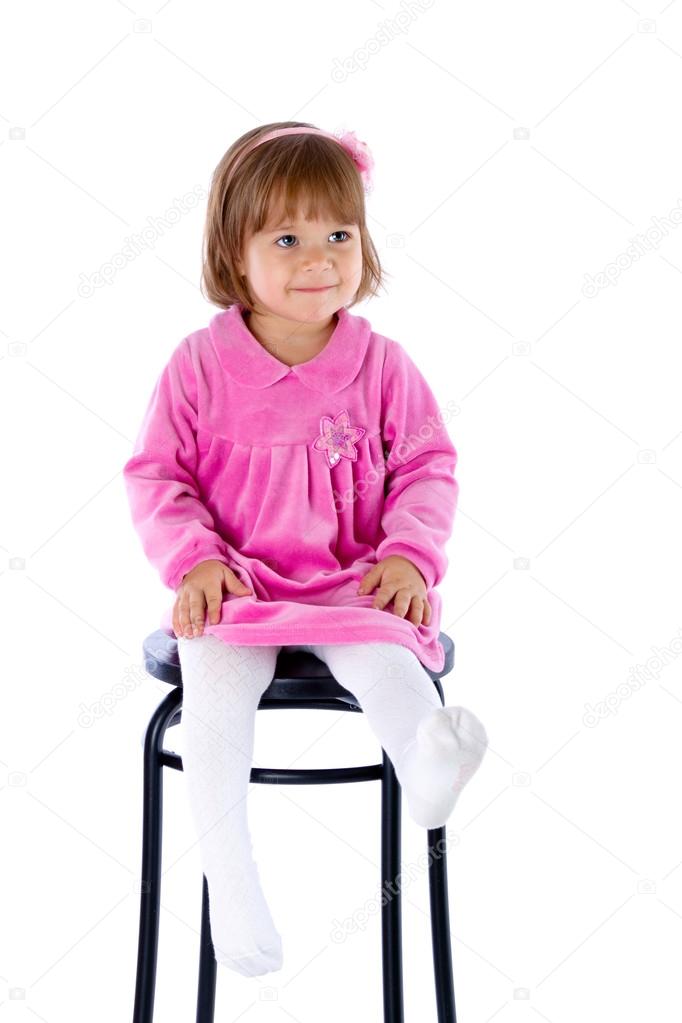 The little girl sits on a high chair