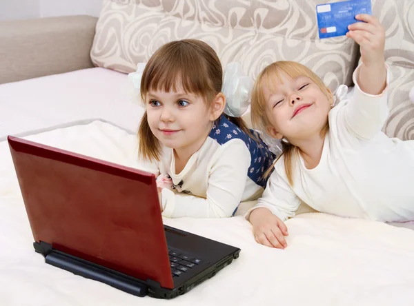 Twee kleine meisjes zijn met een laptop — Stockfoto