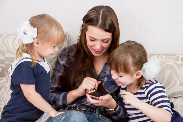 Three sisters with smartphones — Stock Photo, Image