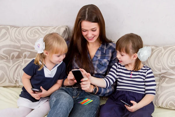 Three sisters with smartphones — Stock Photo, Image