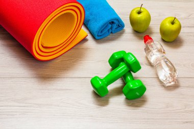 Yoga minderi ve odadaki spor aletleri..