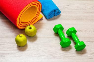 Yoga minderi ve odadaki spor aletleri..