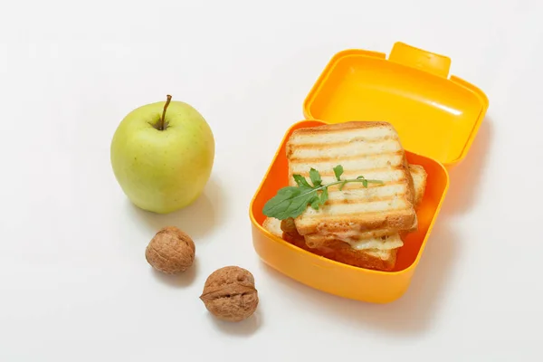 Yellow lunch box with toasted slices of bread, cheese and green parsley. — Stock Photo, Image