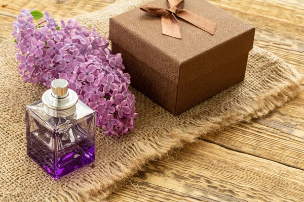 Botella Perfume Una Caja Regalo Marrón Flores Lila Sobre Tela — Foto de Stock