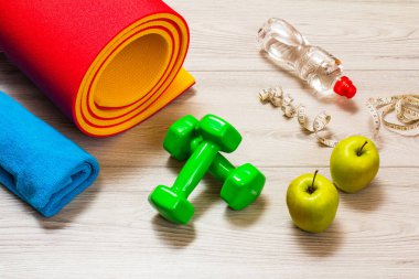 Yoga minderi ve odadaki spor aletleri..