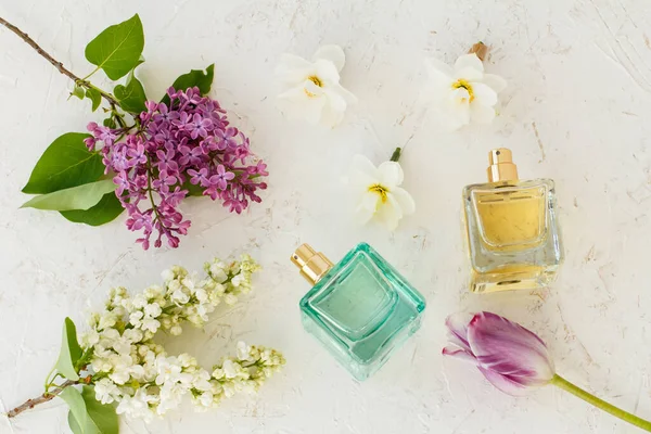 Butelki Kobiecymi Perfumami Pąki Kwiatów Żonkila Liliowe Kwiaty Tulipan Białym — Zdjęcie stockowe