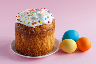 Paskalya pastası ve pembe arka planda renkli Paskalya yumurtaları. Geleneksel Ortodoks Hıristiyan Paskalya Yemeği.