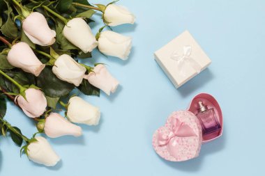 Mavi arka planda güzel beyaz güller olan hediye kutuları. Tatillerde hediye verme kavramı. Üst görünüm.