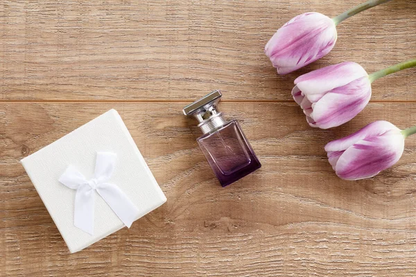 Butelki Perfum Białe Pudełko Drewnianych Deskach Liliowymi Tulipanami — Zdjęcie stockowe