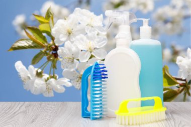 Bulaşık deterjanı şişeleri ve doğal arka planda fırça..