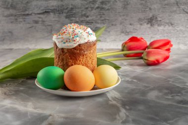 Paskalya pastası ve renkli Paskalya yumurtaları ve lale çiçekleri. Geleneksel Ortodoks Hıristiyan Paskalya Yemeği.