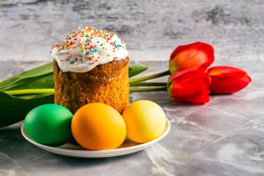 Paskalya pastası ve renkli Paskalya yumurtaları ve lale çiçekleri. Geleneksel Ortodoks Hıristiyan Paskalya Yemeği.