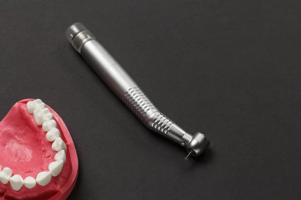 头部高速牙科手镯与Bur和一个布局的人的下巴黑色背景 牙科治疗用的牙科器械 顶部视图 — 图库照片