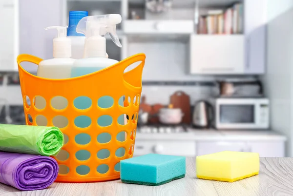 Mutfakta bulaşık deterjanı, mikrodalga fırın, soba, sünger ve çöp torbaları için deterjan bulunan plastik sepet. Yıkama ve temizlik konsepti.