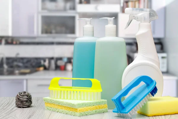 Bottles of dishwashing liquid, glass and tile cleaner and sponges. Fotografia De Stock