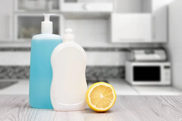 Plastic bottles of dishwashing liquid and a lemon in the kitchen. Washing and cleaning concept.