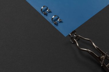 Diş barajı kıskaçlı lastik baraj ve siyah arka planda kauçuk pense. Tıbbi aletler konsepti. Üst görünüm.