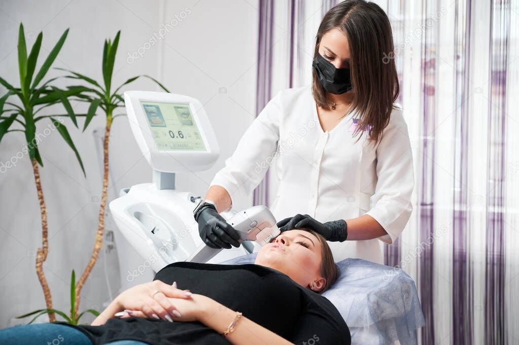 Beautician doing procedure for cleaning skin face.