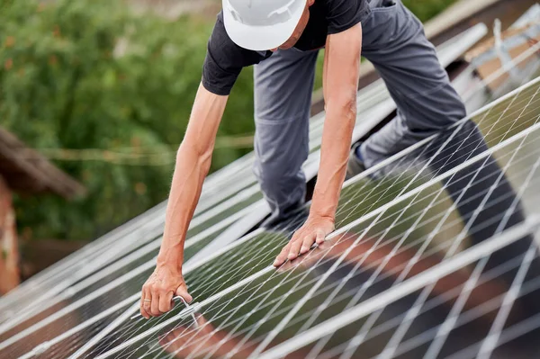 Människan arbetare montering solpaneler på taket av huset. — Stockfoto
