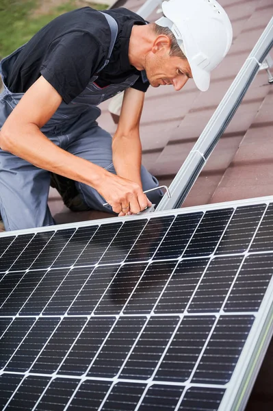 Man worker mounting solar panels on roof of house. — Stock Photo, Image