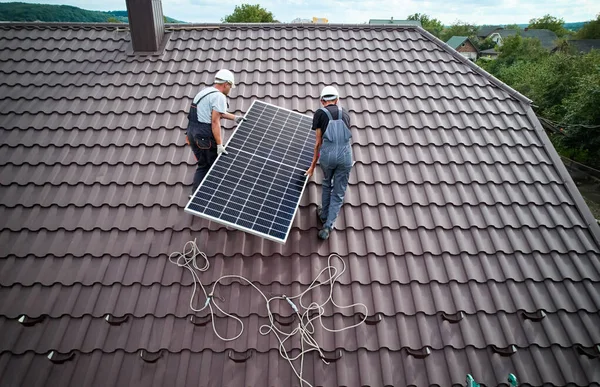 Techniker montieren Photovoltaik-Solarmodule auf Hausdach. — Stockfoto