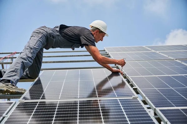 Férfi munkavállaló szerelése fotovoltaikus napelem rendszer szabadban. — Stock Fotó