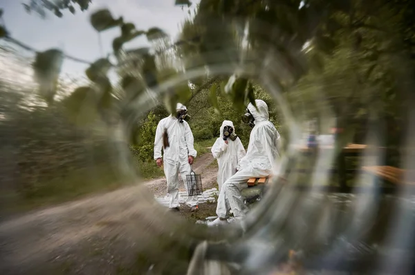 Ecologistas en trajes de radiación en el bosque a través de un círculo borroso. — Foto de Stock