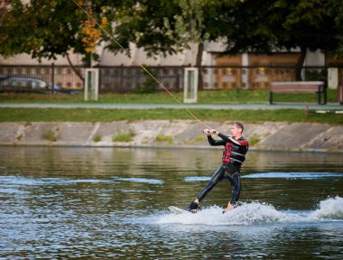 Kablo parkında sörf yaparken eğlenen genç sörfçü..
