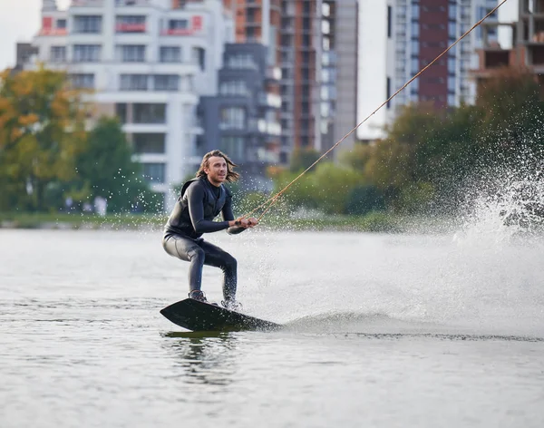 Jonge surfer die plezier heeft met wakeboarden in het kabelpark. — Stockfoto