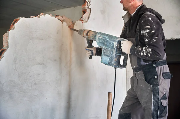 Vágott nézeti munkás perforátorral a bontási fal alatt. — Stock Fotó