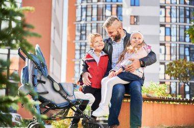 Mutlu baba, güneşli bir günde çocuklarla vakit geçiriyor..