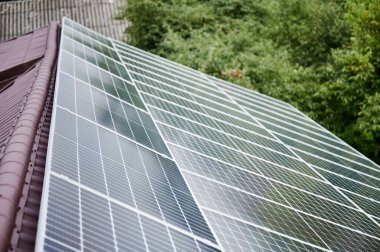 Çatıda güneş fotovoltaik panel sistemi olan modern bir ev.