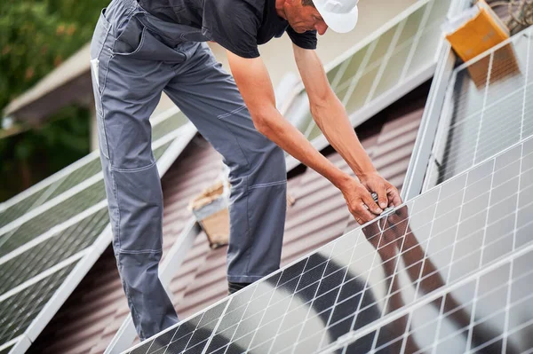 Man worker mounting solar panels on roof of house. — Stock Photo, Image