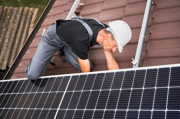 Man worker mounting solar panels on roof of house. — Stock Photo, Image