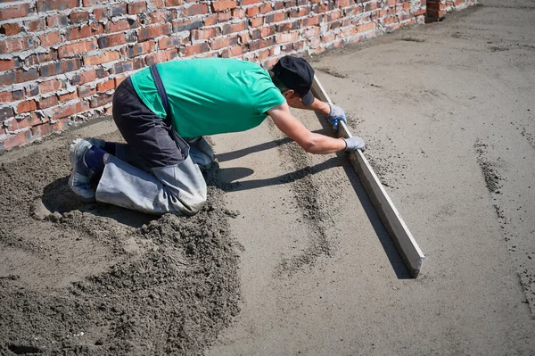 Manlig byggare skruvning golv på byggarbetsplatsen. — Stockfoto