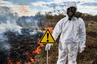 Gaz maskeli itfaiyeci ekolojist orman yangını alanında çalışıyor..