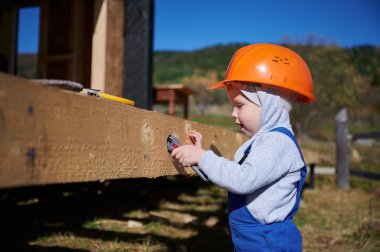 Boy toddler playing as builder on construction site