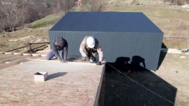 Marangoz, tahta çerçeve inşa ederken OSB paneline çivi çakıyor..