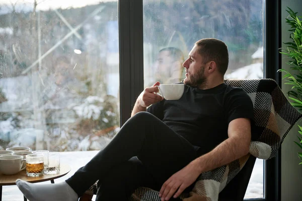 Man enjoying weekends inside contemporary cottage.