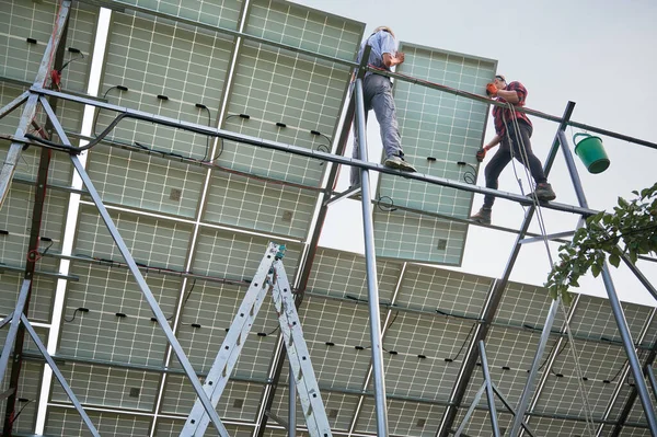 Metal kirişlere güneş panelleri kuran işçiler — Stok fotoğraf