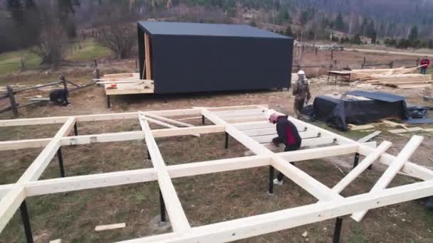 Mężczyźni Budują Drewniany Dom Szkieletowy Fundamentach Stosu Stolarze Montują Drewniane — Wideo stockowe